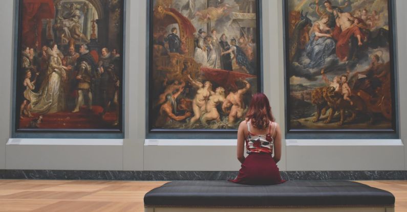 Museums - Woman Sitting on Ottoman in Front of Three Paintings
