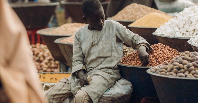 Outdoor Markets - Boy Sitting on Sack on Outdoor Market